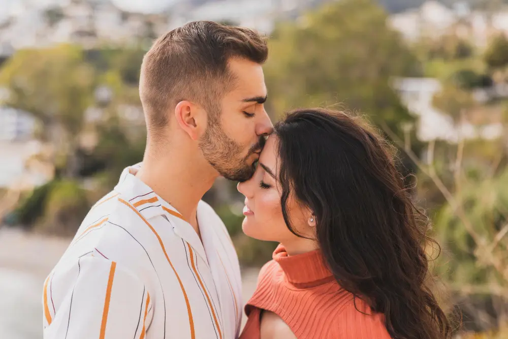 Boyfriend kissing girlfriend on the forehead in a tender moment