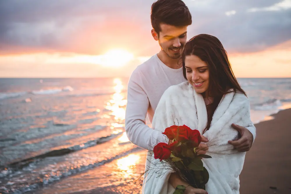 Man and woman walking together on the beach, relaxed and close