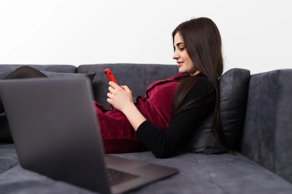 Woman thoughtfully evaluating an adult dating site on her mobile phone